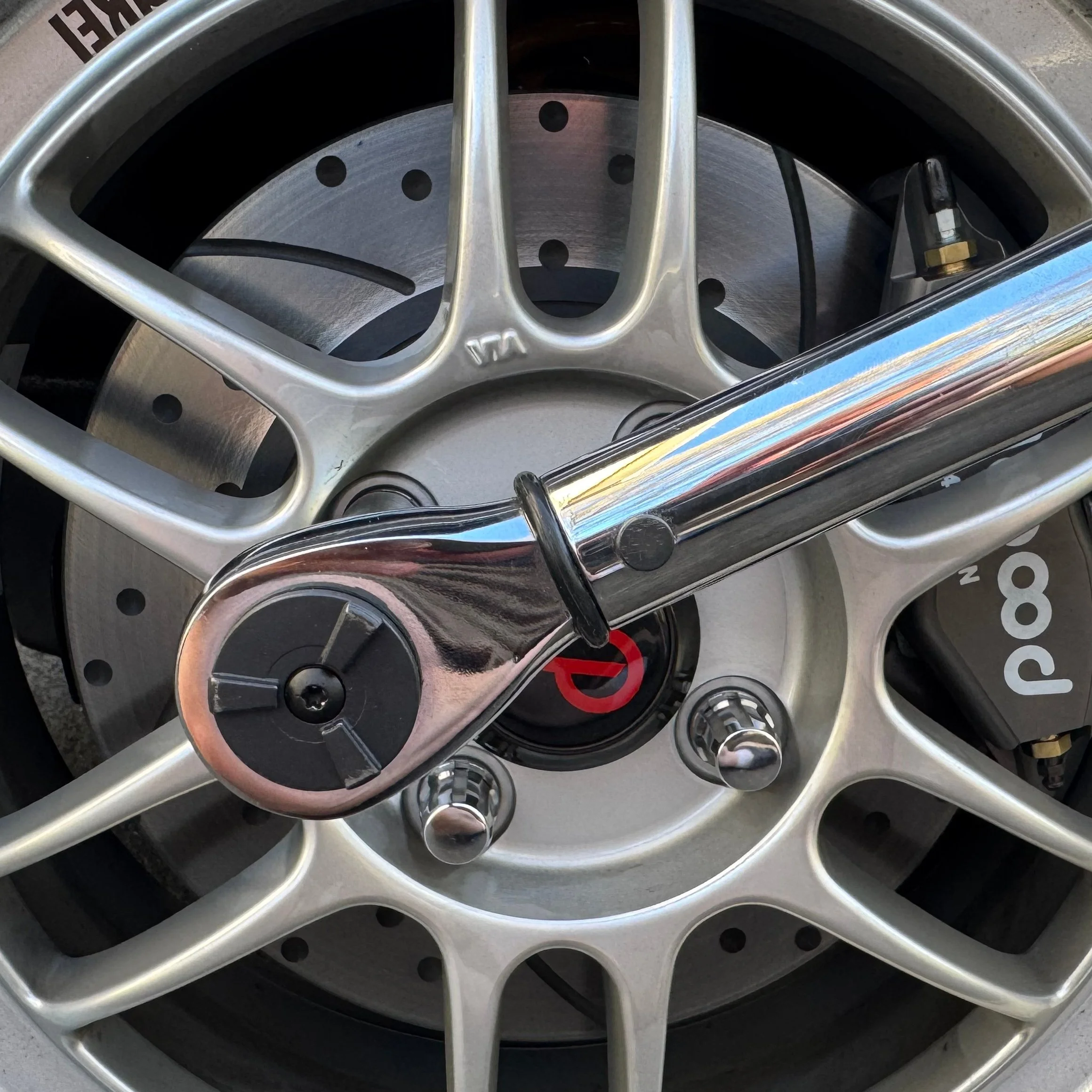 Enkei RPF1 wheel on a 1990 NA Miata MX-5 with torque wrench. Link leads to NA Torque Specs section of website.