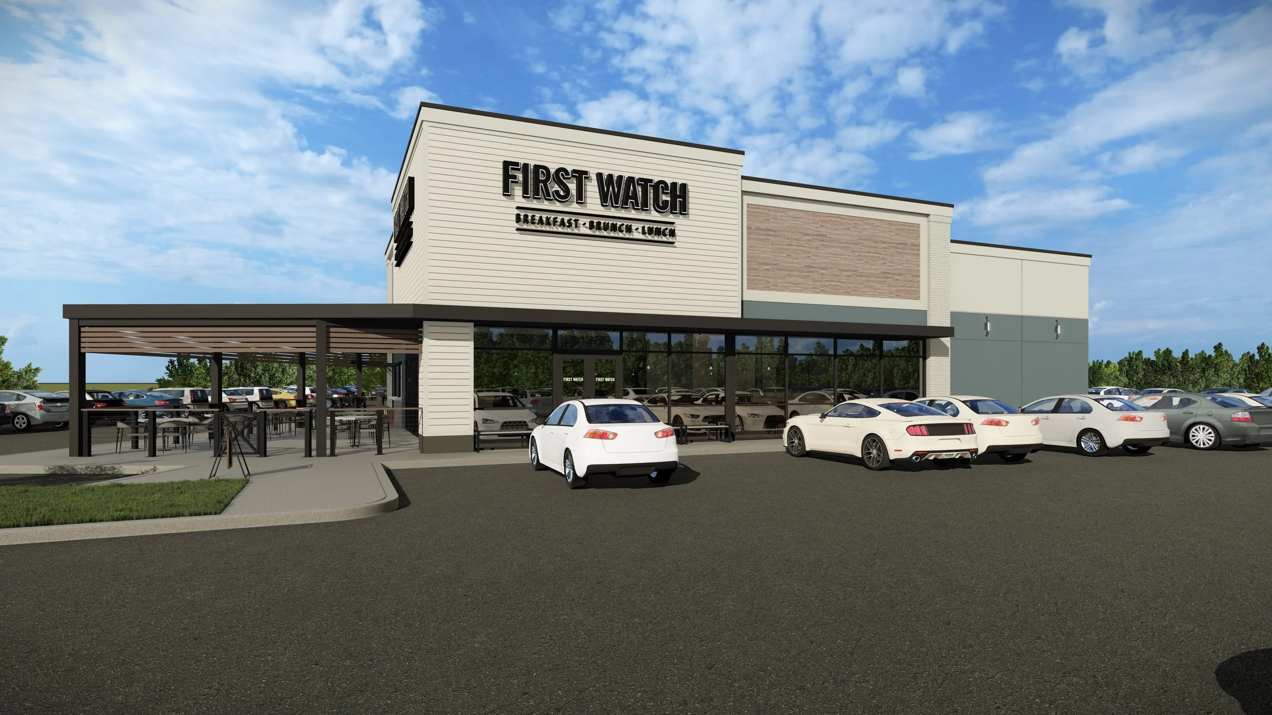 Exterior view of First Watch restaurant with parking lot, several cars, and outdoor seating area, under a partly cloudy sky.