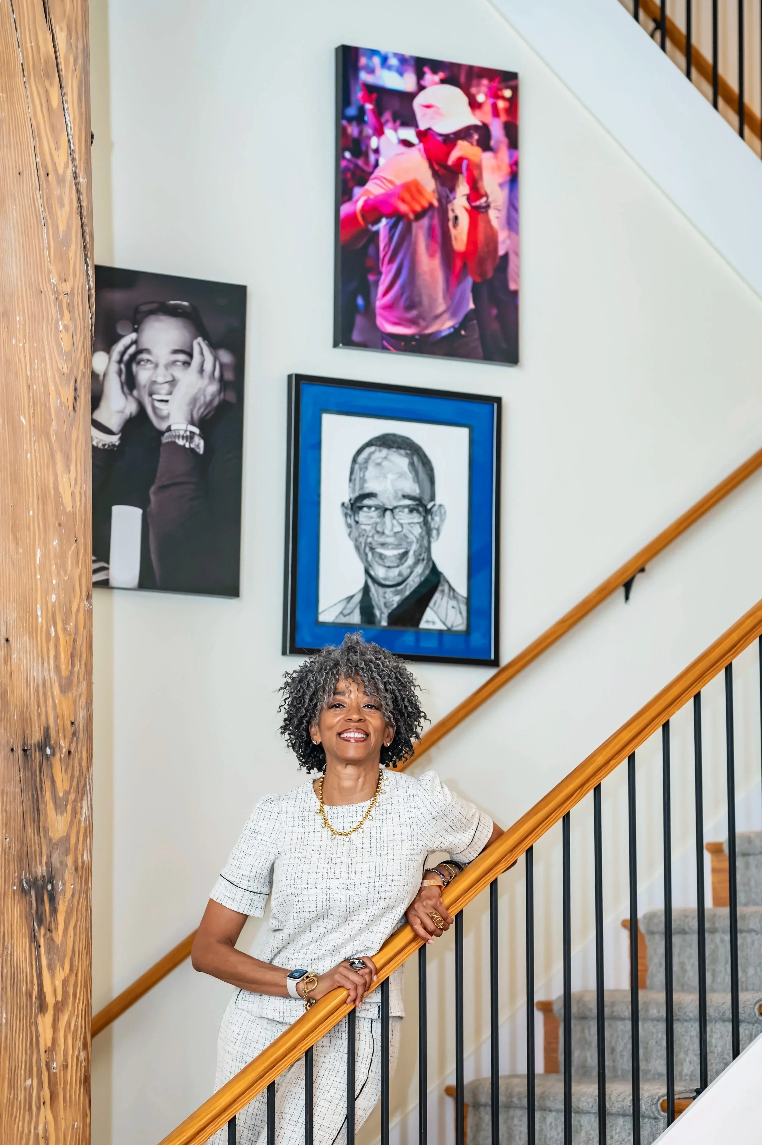 Susan on a staircase in front of pictures of her brother Stuart Scott, the ESPN sportscaster.