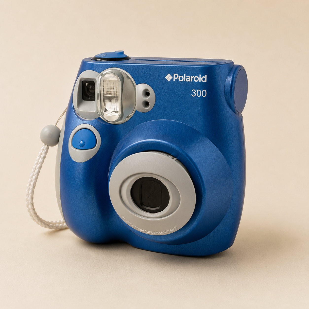 A blue Polaroid 300 instant camera with a white wrist strap against a neutral background.