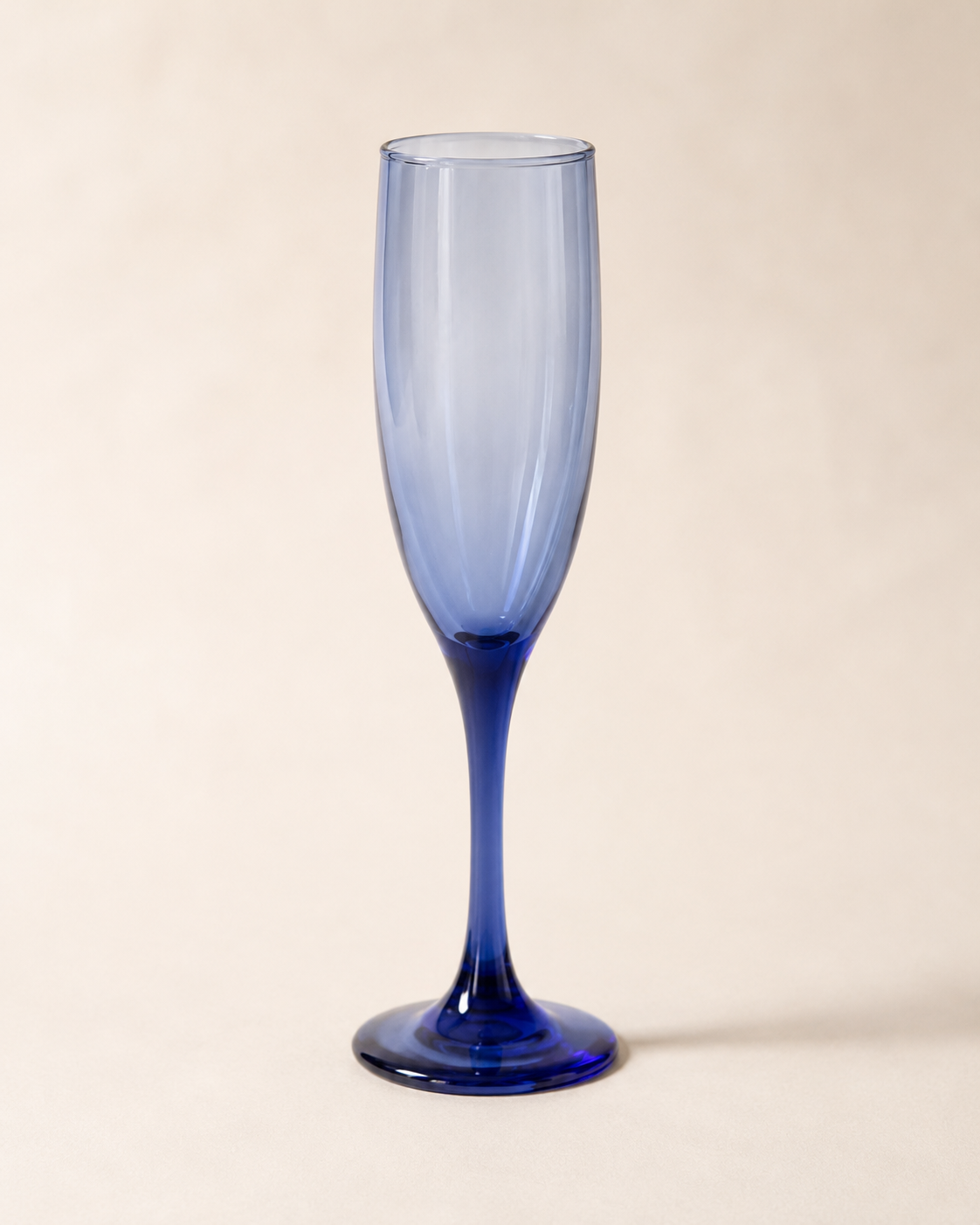 A tall, elegant blue glass champagne flute with a slender stem and a smooth, curved bowl.