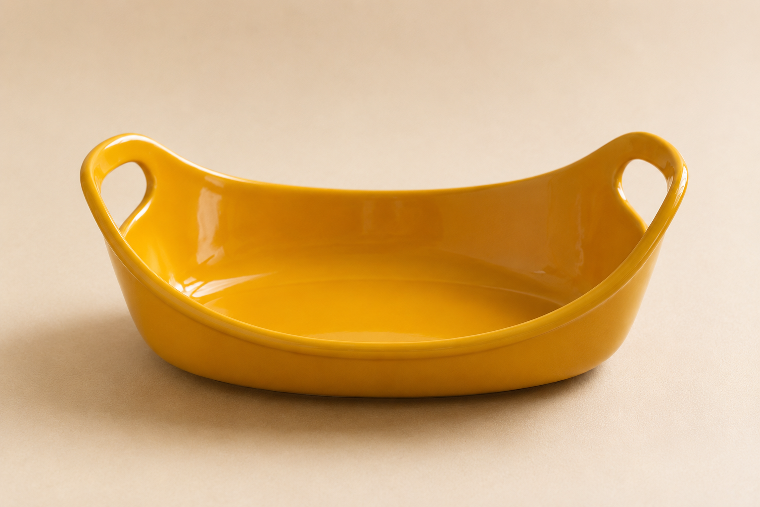 Yellow ceramic bowl with handles on a beige surface.
