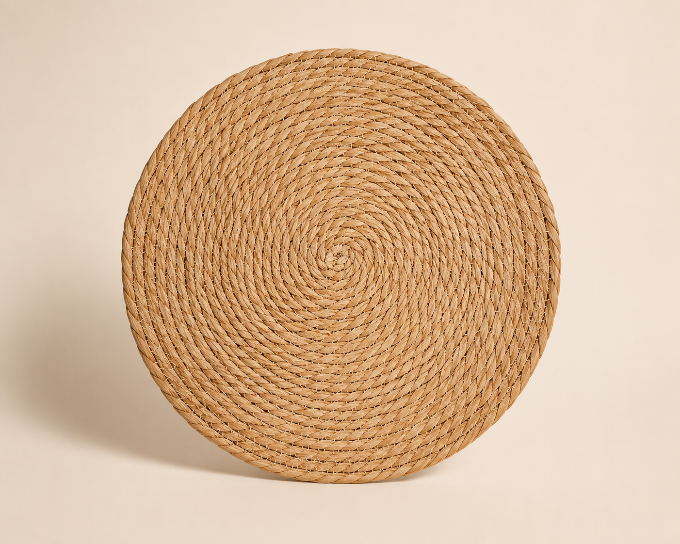 Round woven rattan placemat on a beige background.