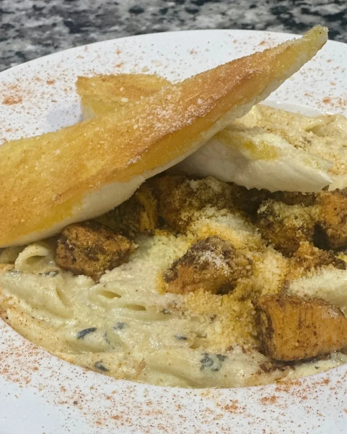 Fried fish fillet served with creamy pasta and spaghetti squash topped with grated cheese and spices.