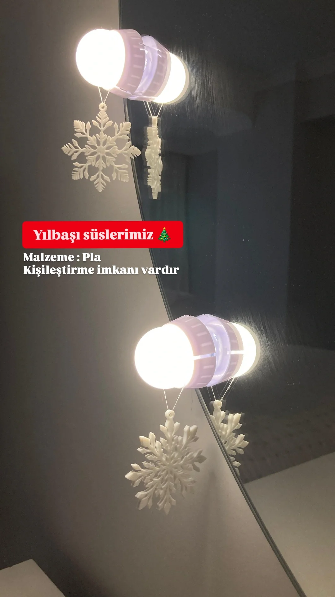 White LED lights with snowflake decorations hanging on a dark wall. Red banner with Turkish text and white text below.