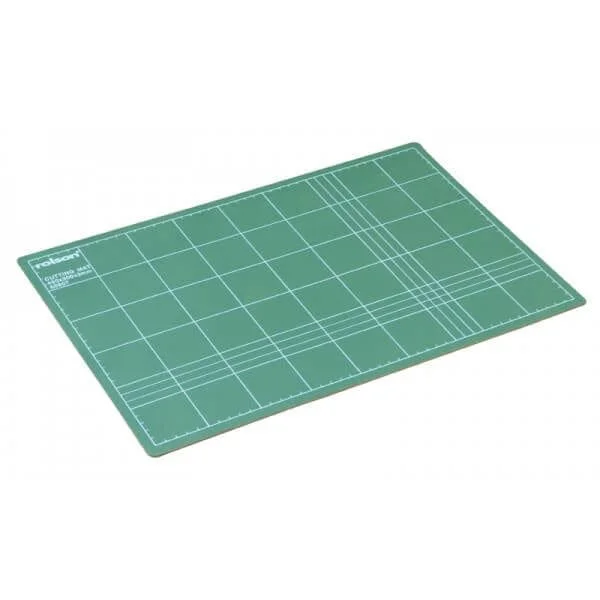 Green cutting mat with grid lines and measurement marks.