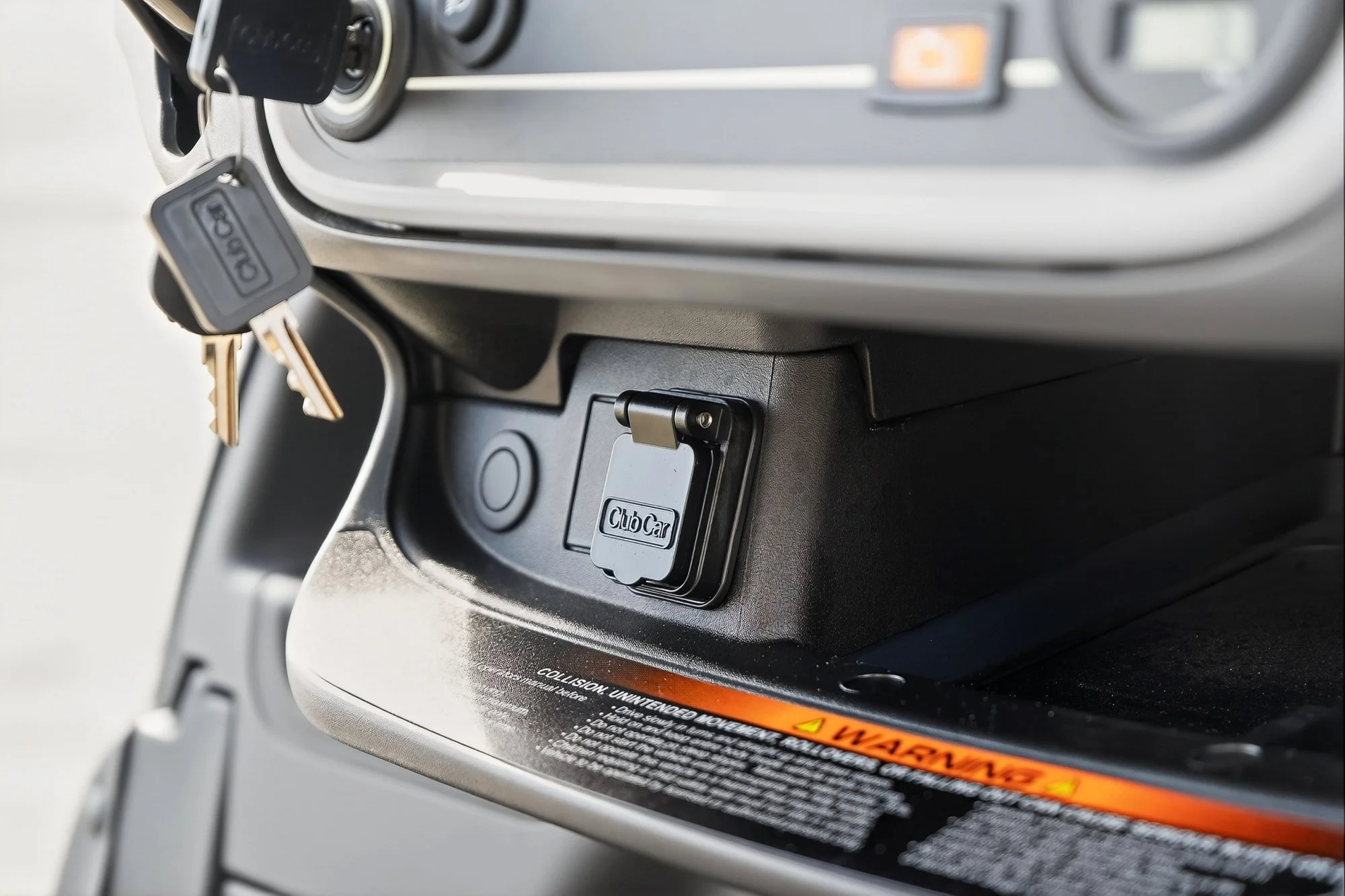 Close-up of a vintage Caro Max vehicle dashboard with a key hanging from the ignition and a compartment labeled 'Club Car' below.