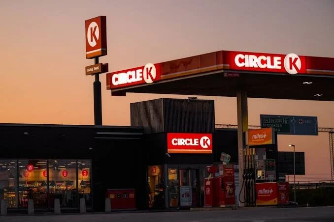 A Circle K convenience store and gas station during sunset or dusk, with illuminated signs and fuel pumps in front.