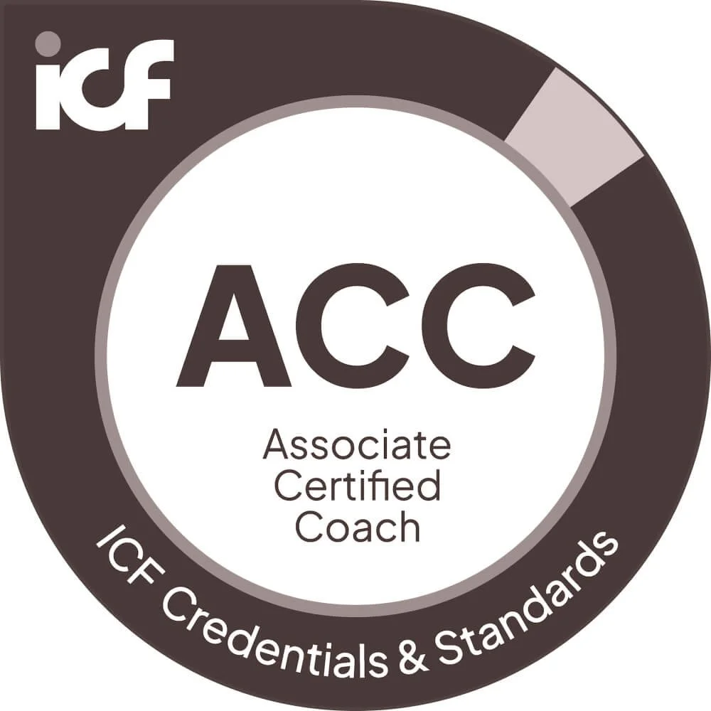 Certification badge for Associate Certified Coach from ICF, featuring a circular design with a dark outer ring and a white center, with the acronym 'ACC' and the full title below it.