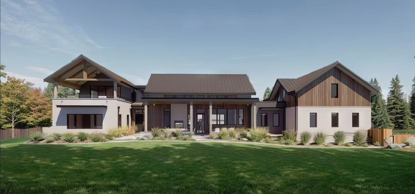 Modern house with multiple sections, large windows, and a landscaped front yard with grass and bushes, backed by trees and a clear sky.