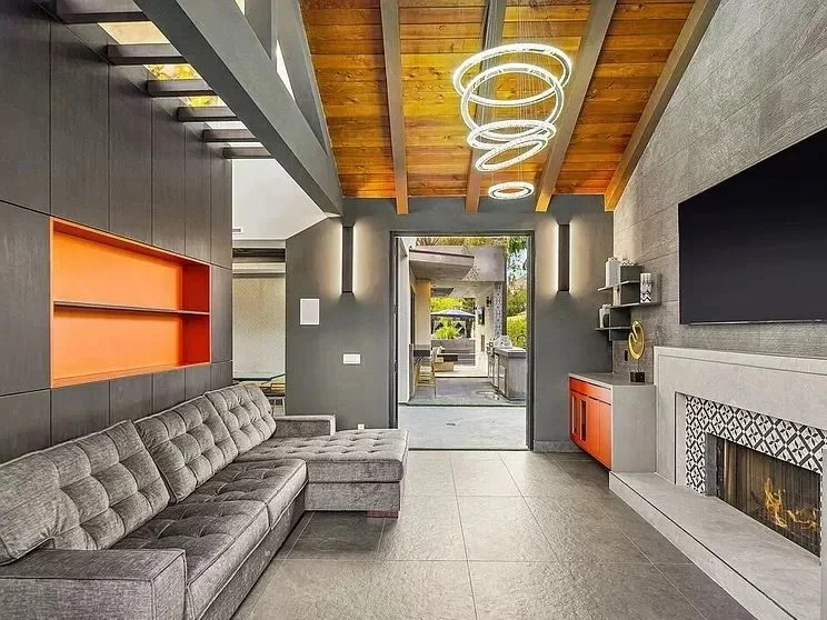 Contemporary living room featuring an 11‑foot gray central storage unit, a copper central decorative space, large windows, and modern pendant lights