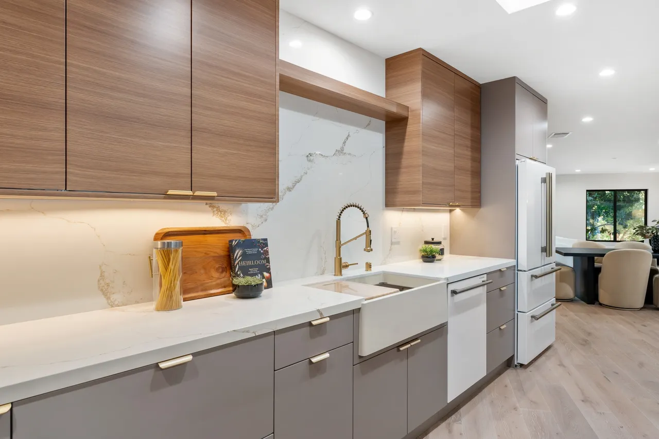 Contemporary sink wall featuring wood‑grain upper cabinets and minimalist matte gray lower storage.