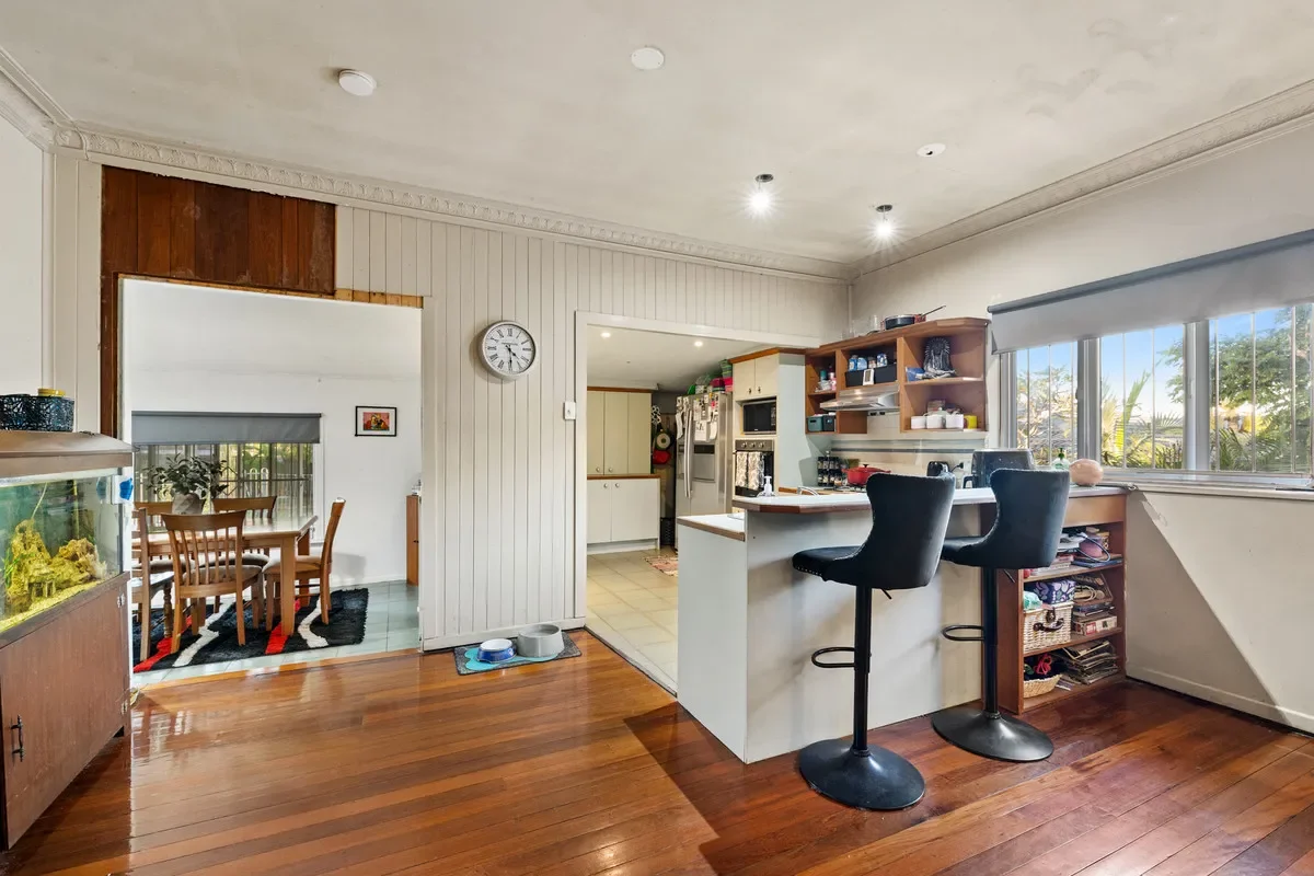 Kitchen at 18 Daveson Road, Capalaba, with a raised counter and stools, adjoining dining area and timber flooring.