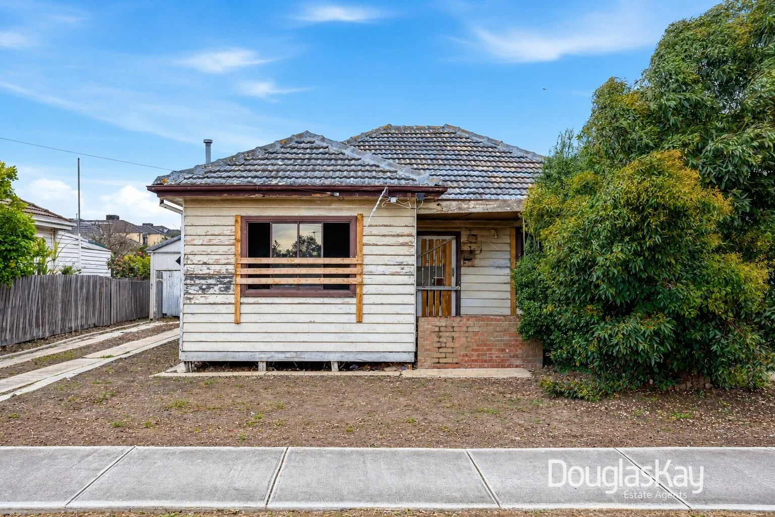 Rear exterior of 10 Busch Street, Sunshine North showing the weatherboard house, tiled roof, side driveway and backyard.