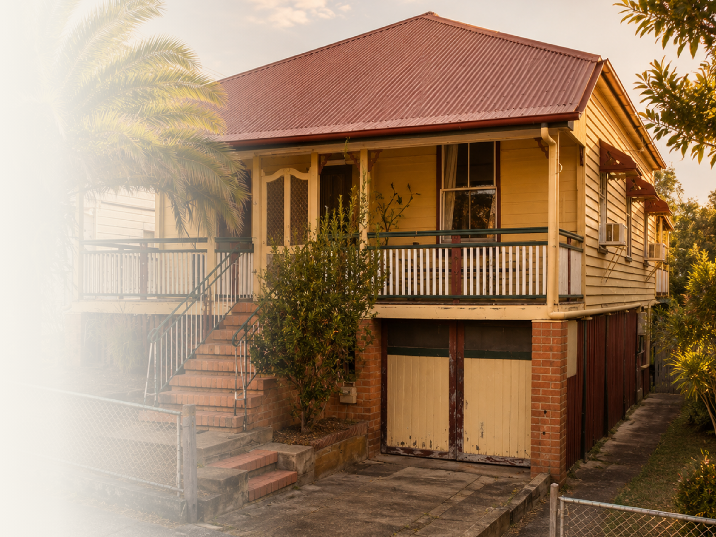 Brick and yellow weatherboard cottage with a verandah and metal fence.