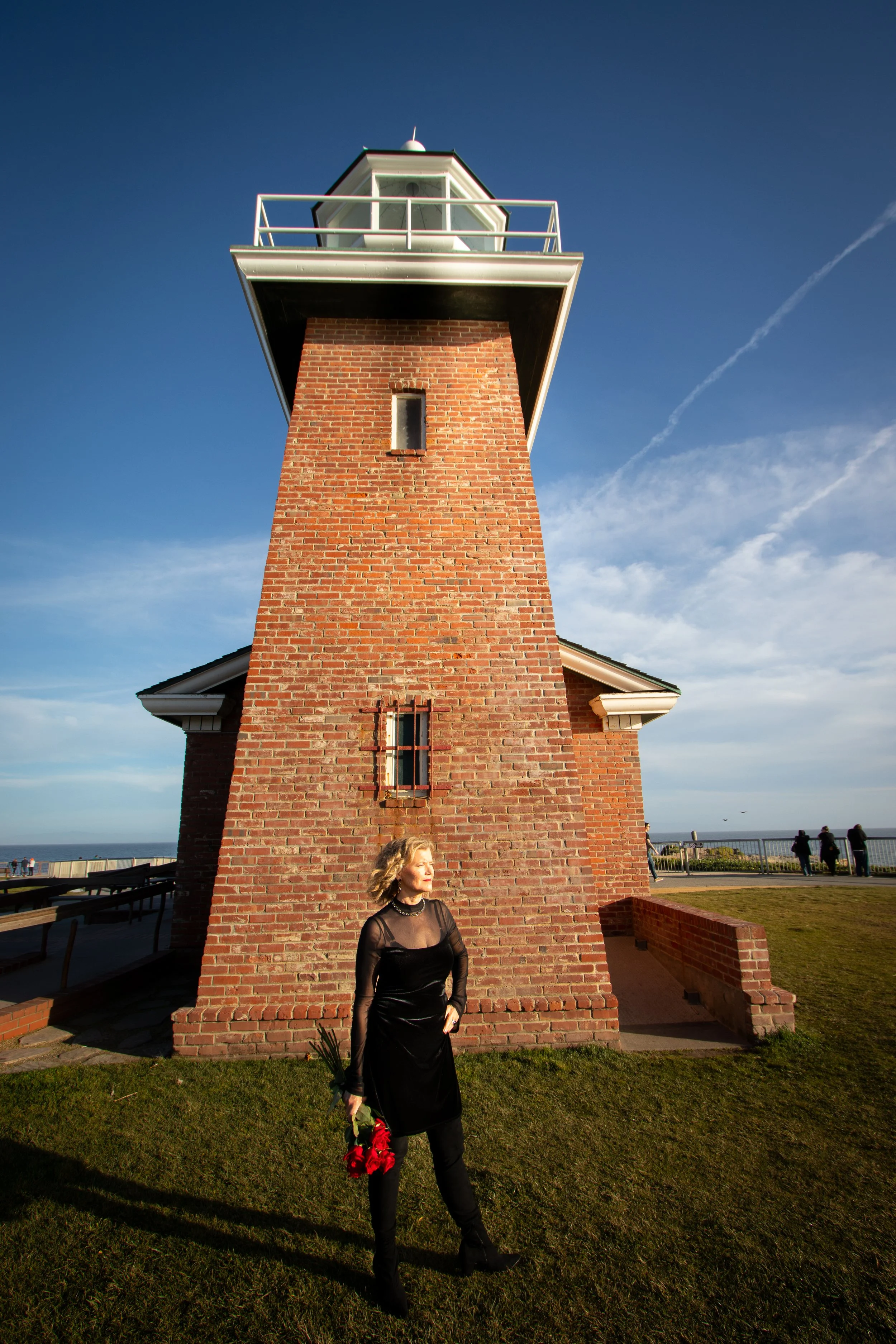 woman standing near lighthouse by the ocean representing guidance and clarity