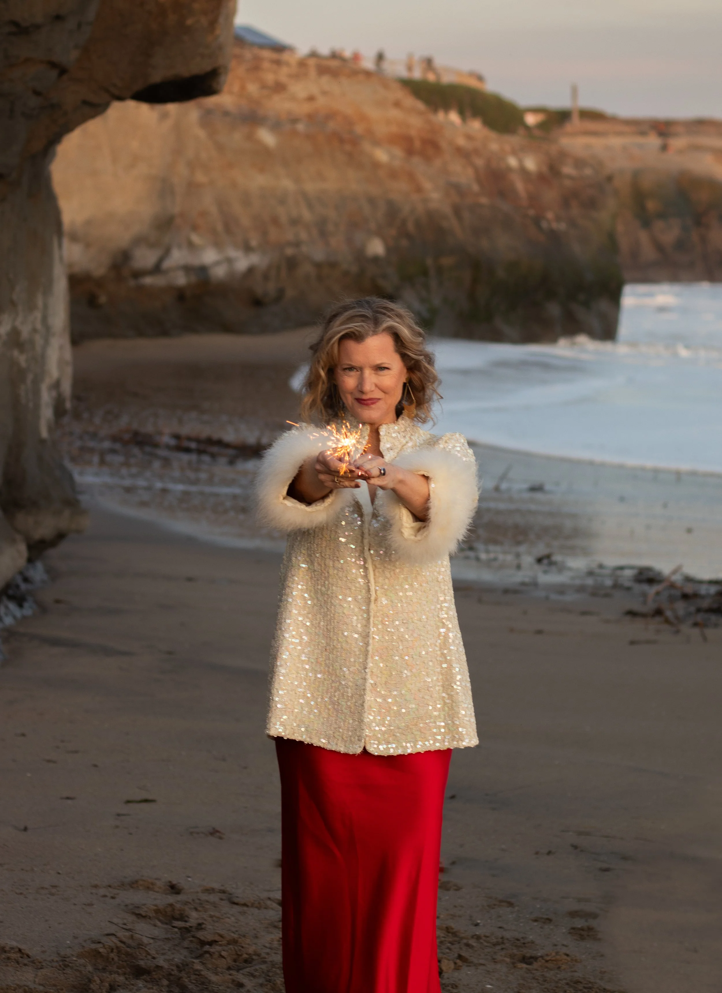 intuitive healer on beach with arms open representing emotional release and personal transformation