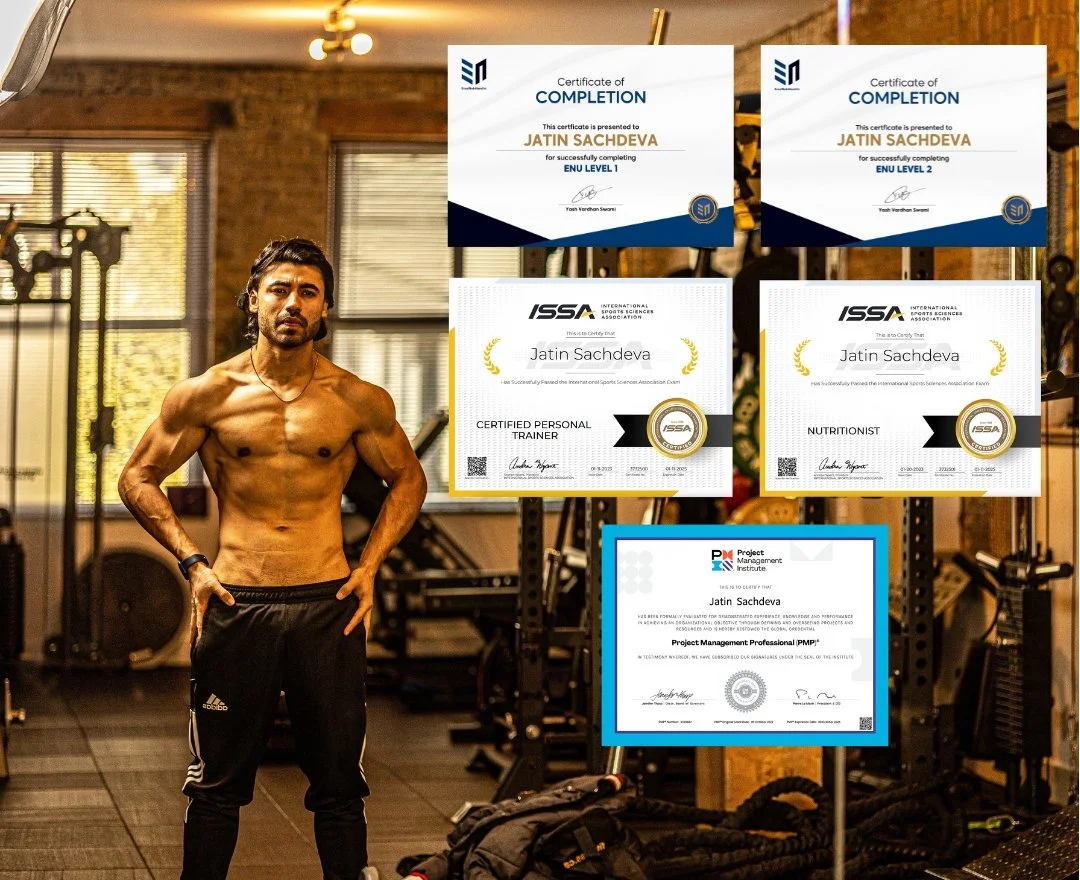 A shirtless man with long dark hair standing in a gym with certification posters behind him.