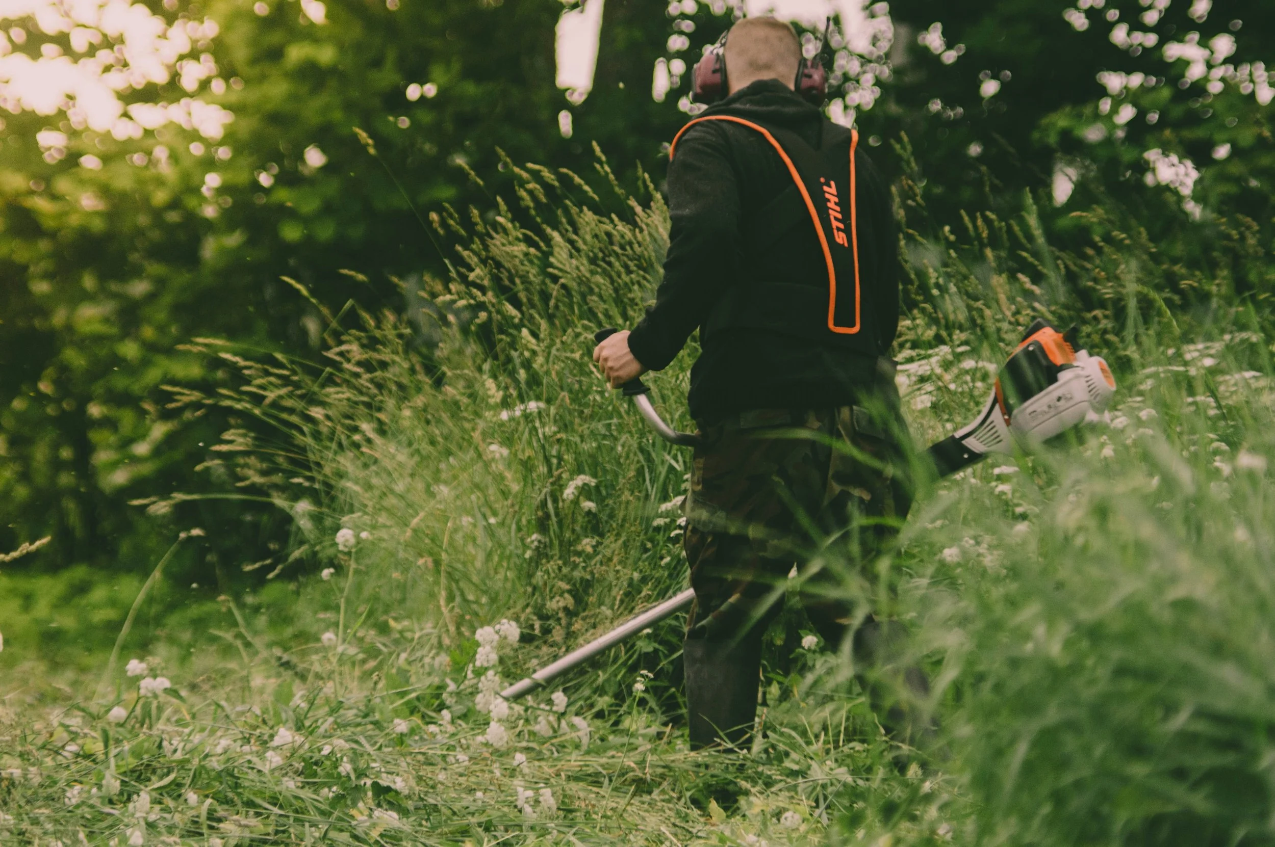 Person using a strimmer to clear site.