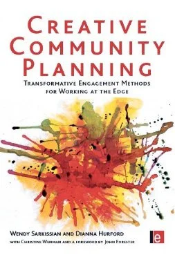 Book cover titled 'Creative Community Planning' with colorful paint splashes.