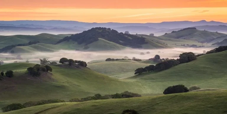 Sunrise over Petaluma wine country. Layers of hills and valleys with fog and a beautiful colorful sky.