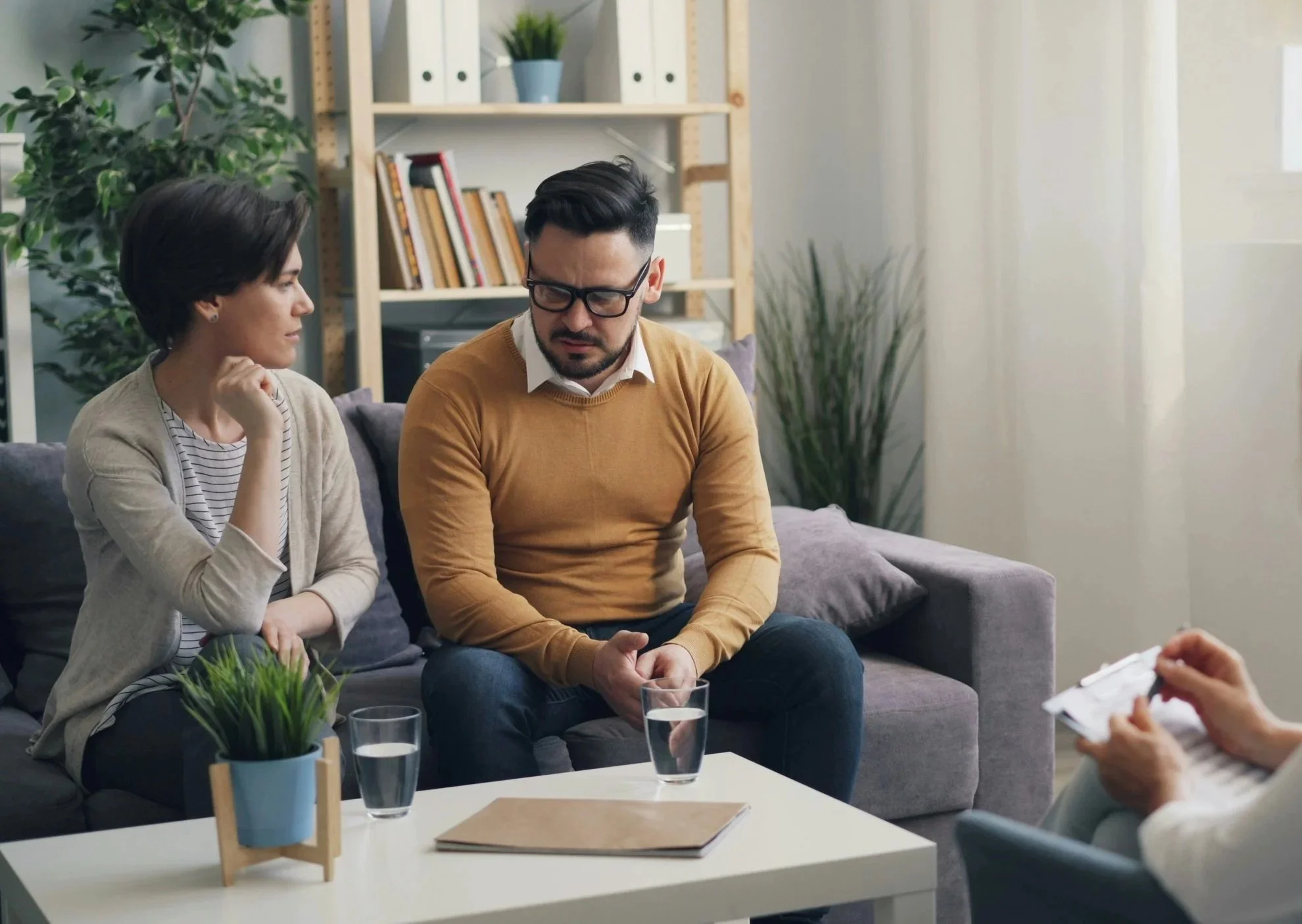 two adults talk on a couch