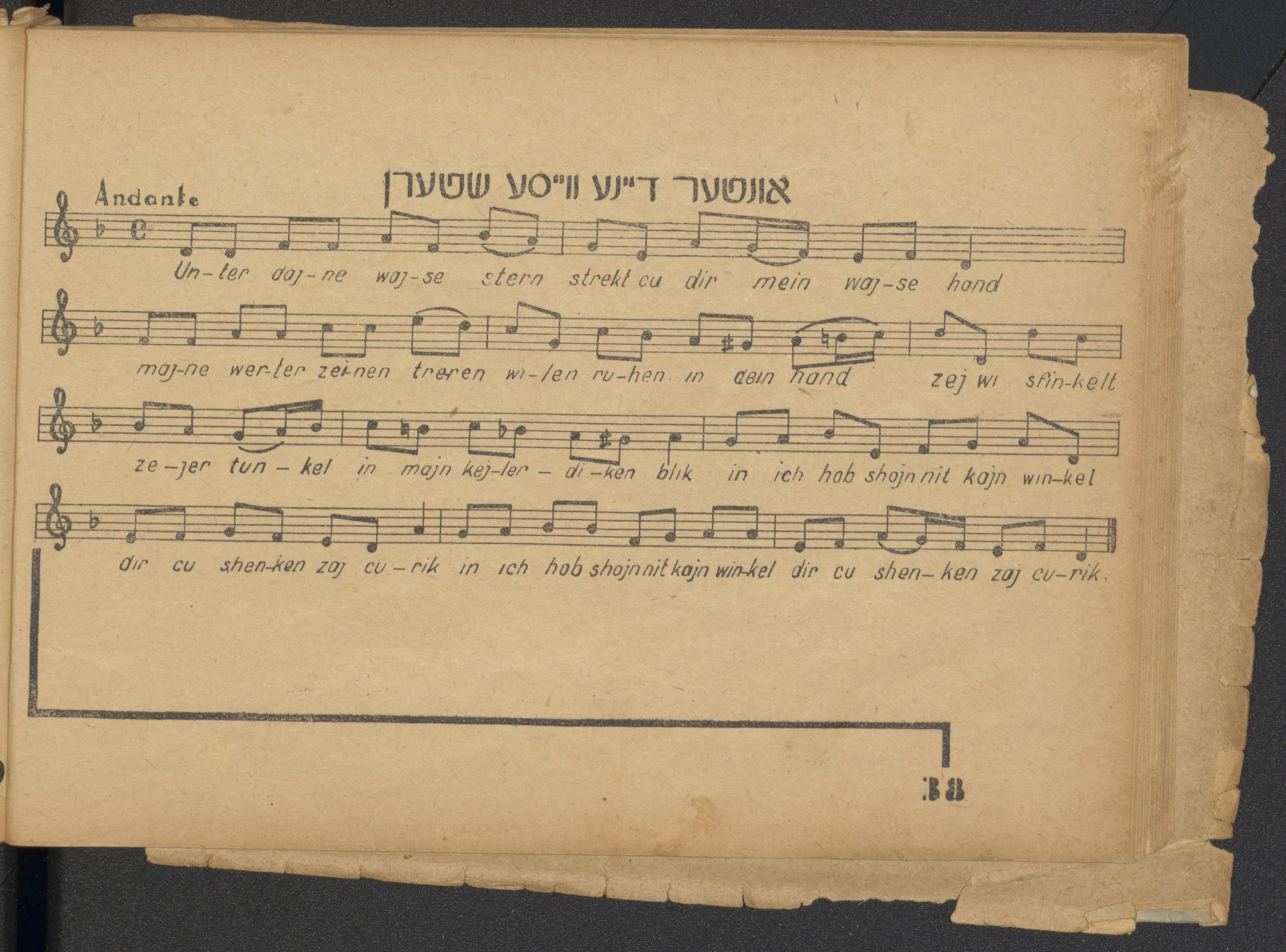 A sheet of vintage music with handwritten German lyrics and musical notes, labeled 'Andante', on aged paper with torn edges.