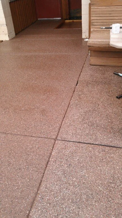 Reddish-Brown exposed concrete aggregate section of a back patio