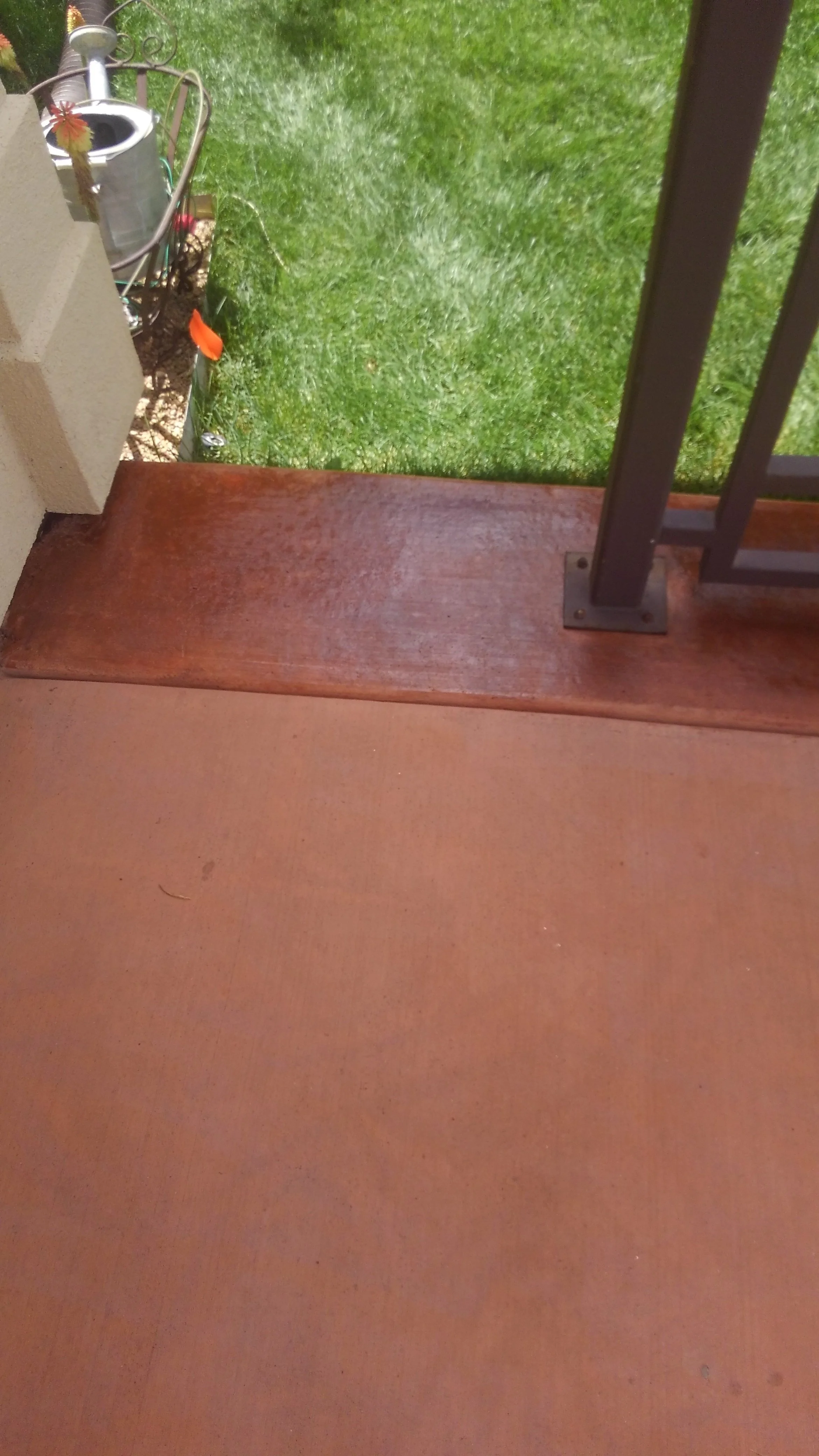 Outdoor space with reddish-brown staining on concrete patio.