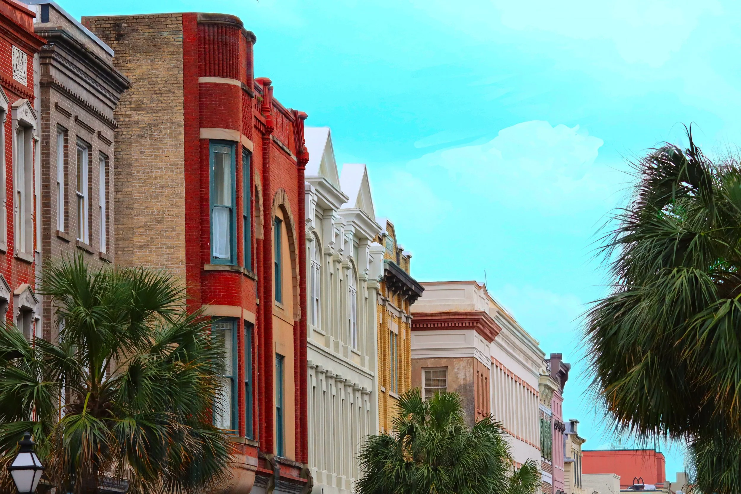 Colorful row of historic buildings with palm trees and a blue sky.