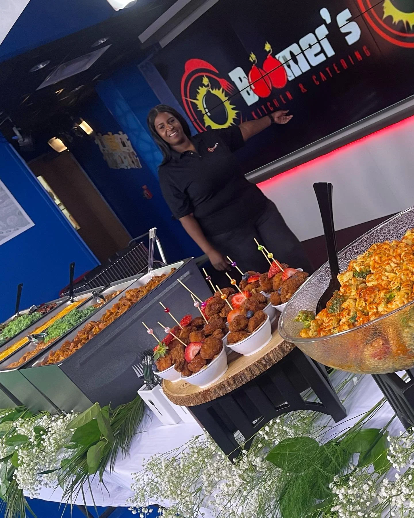 Boomer smiling at her catering table with various dishes