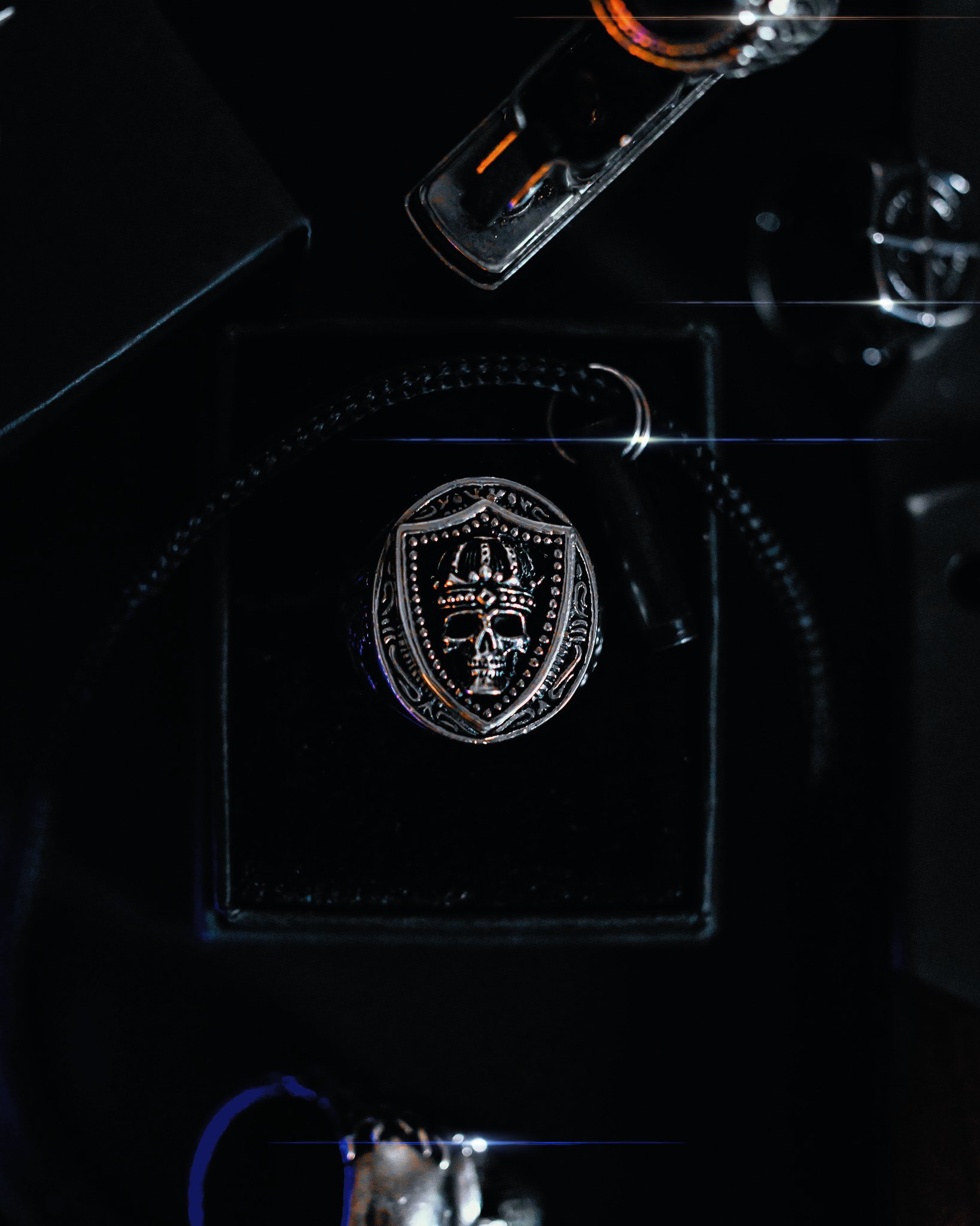Close-up of a glass bottle pouring liquid into a container on a dark surface, with a skull emblem on the container, illuminated by subtle lighting.