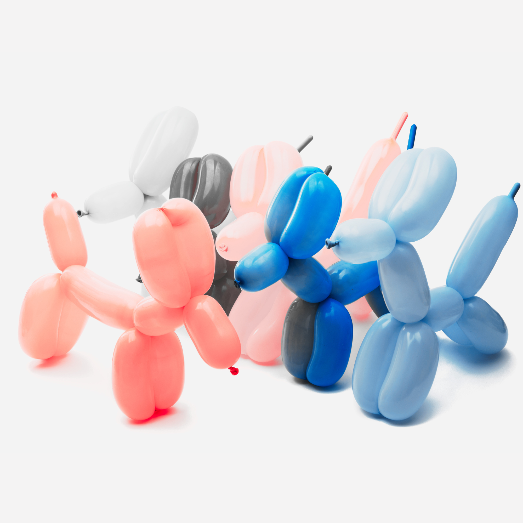 Colorful balloons arranged in abstract shapes with a pale background.
