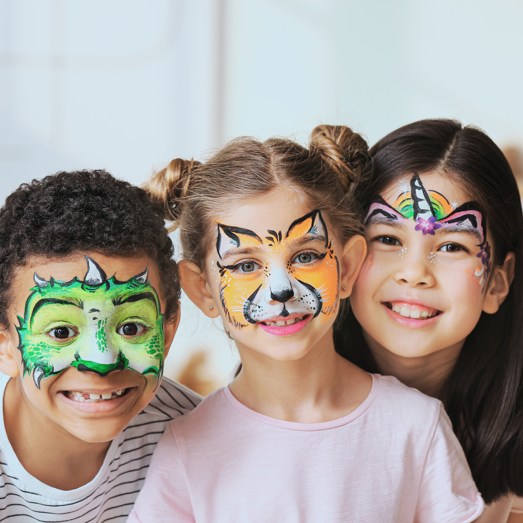 Children with face paint of various colorful characters, smiling and appearing happy.