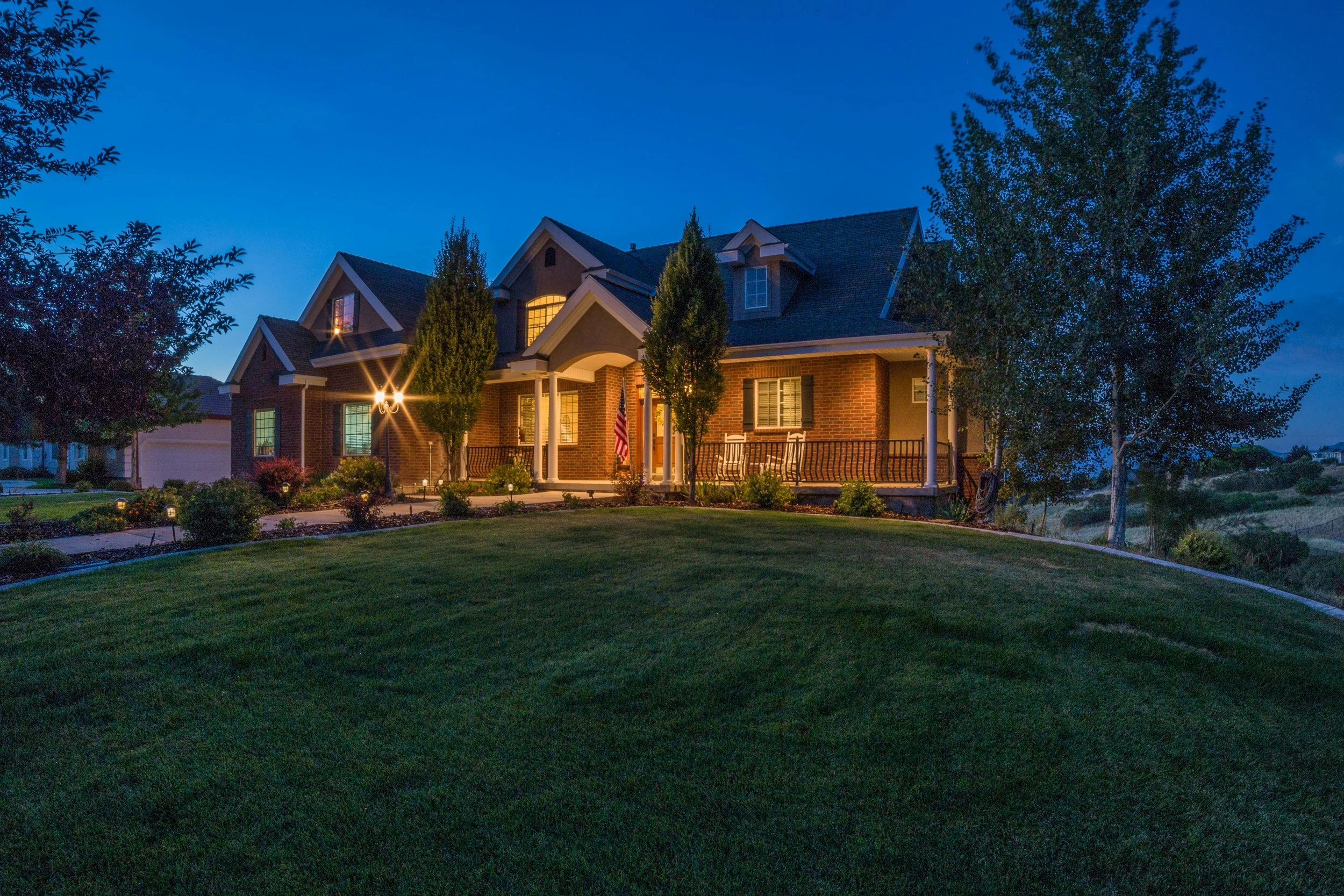 Luxury home exterior at dusk in Salt Lake City showcasing a well-maintained property protected by professional pest control services.