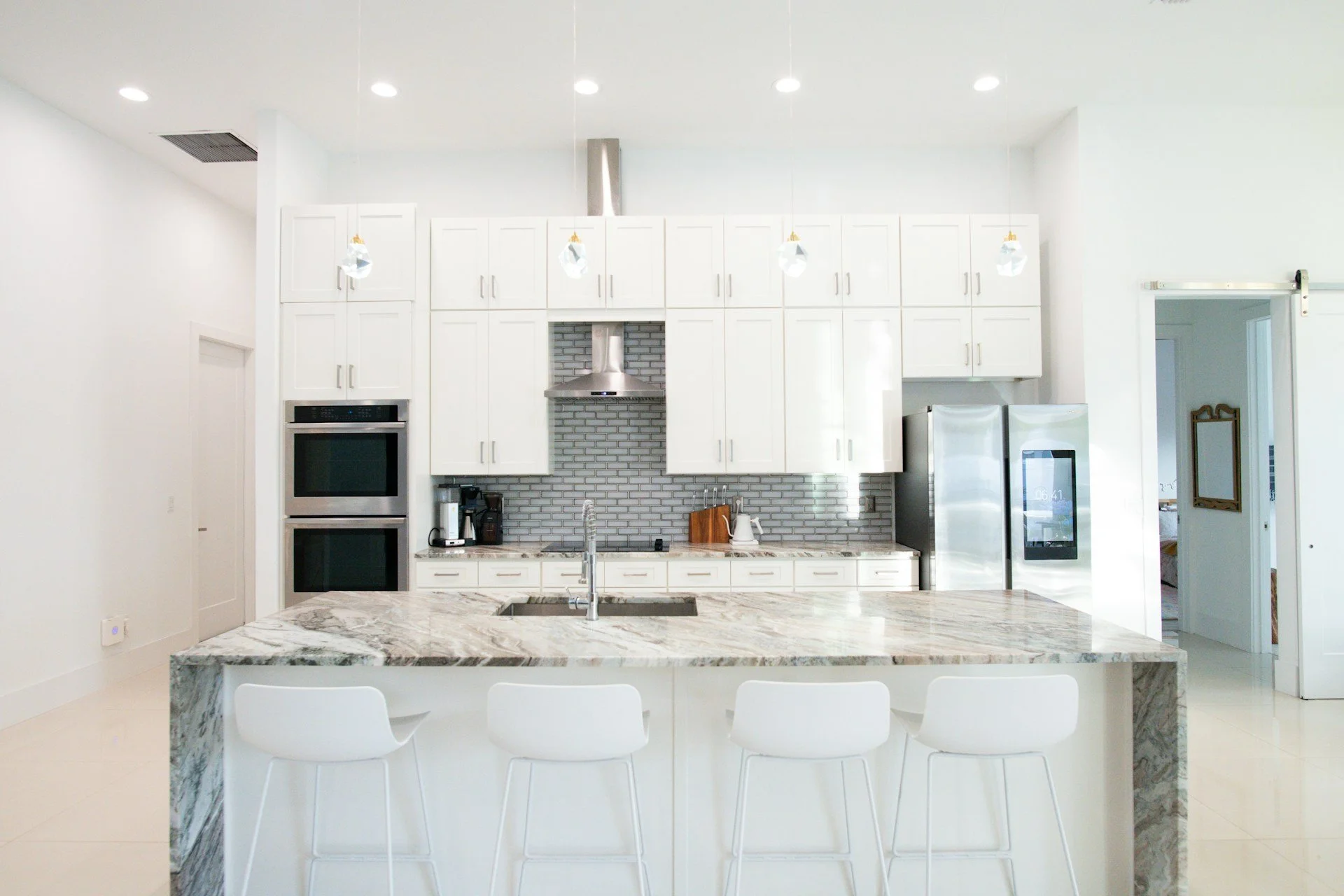 Bright kitchen featuring a large granite island with natural mineral patterns.