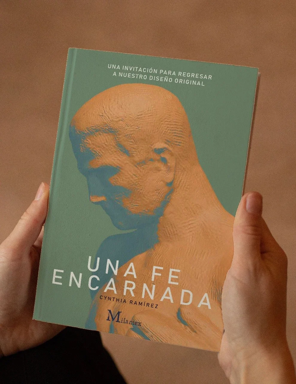 A person is holding a book titled 'Una fe encerrada' by Cynthia Ramírez.