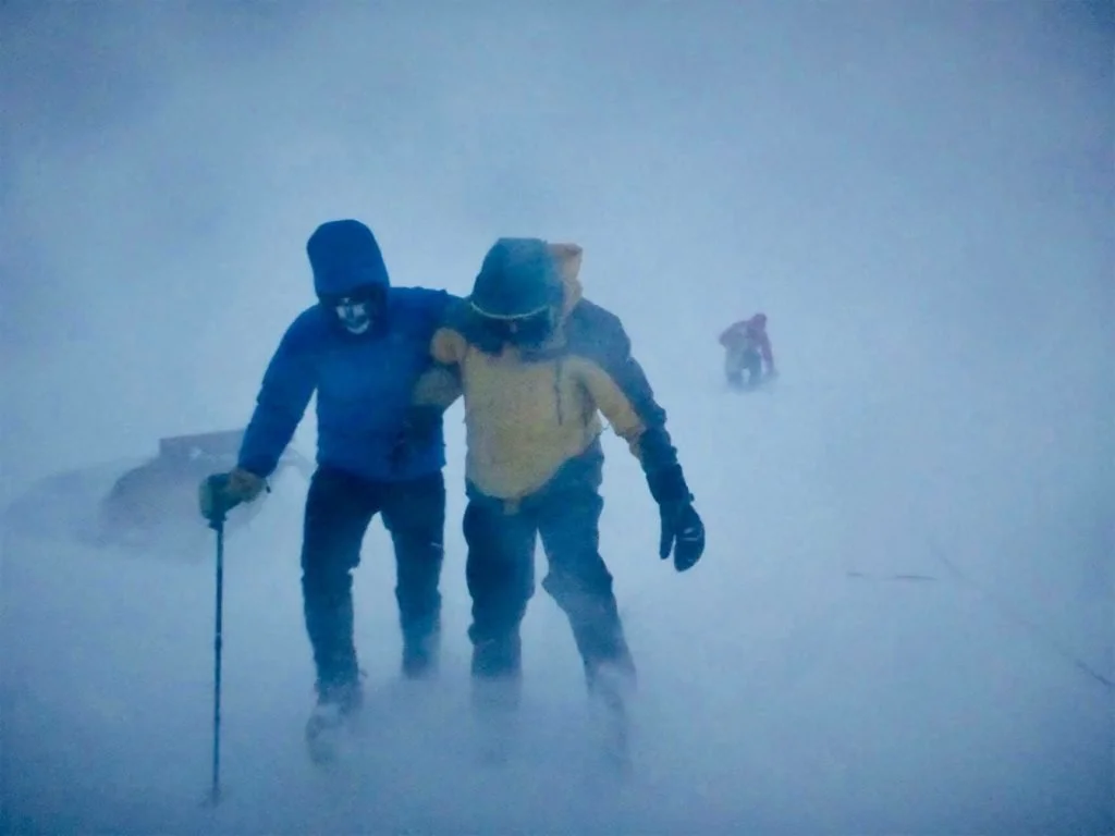 hikers battling the blizzard by trudging through the snow