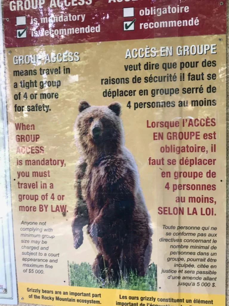 signpost warning to travel in groups for safety from bears