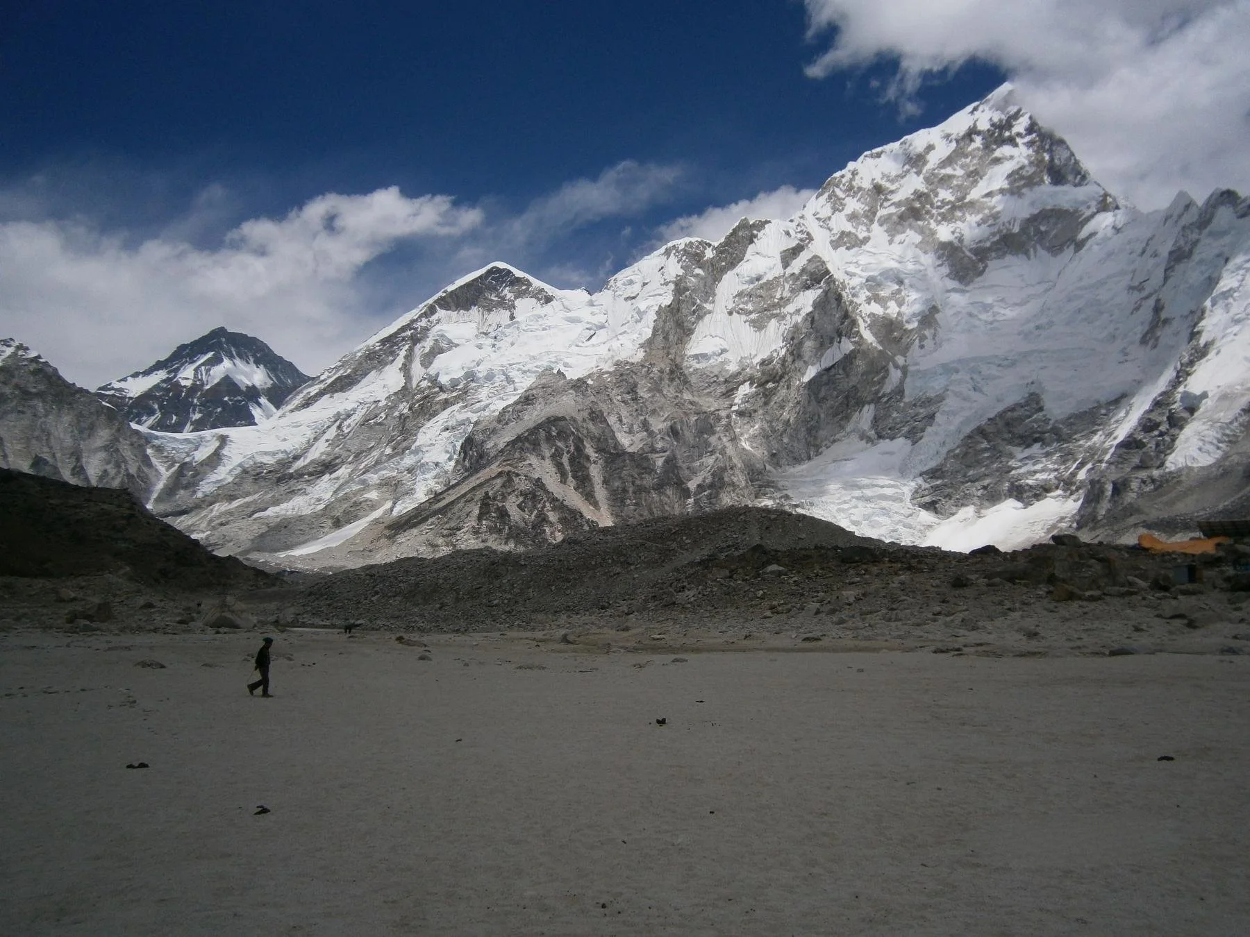 a trekker walking on flat ground with a Himalayan backdrop