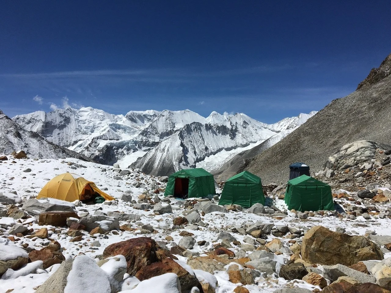 Tents pitched in snow overlooking a wide mountain vista at Makalu Advance Base Camp in Nepal