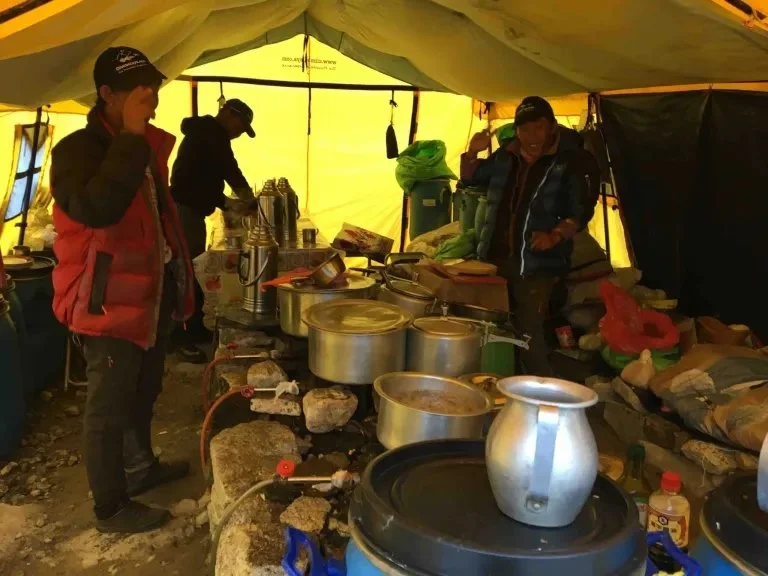 inside the Kitchen tent at ABC with kitchen crew preparing meals and lots of pots and pans on stoves