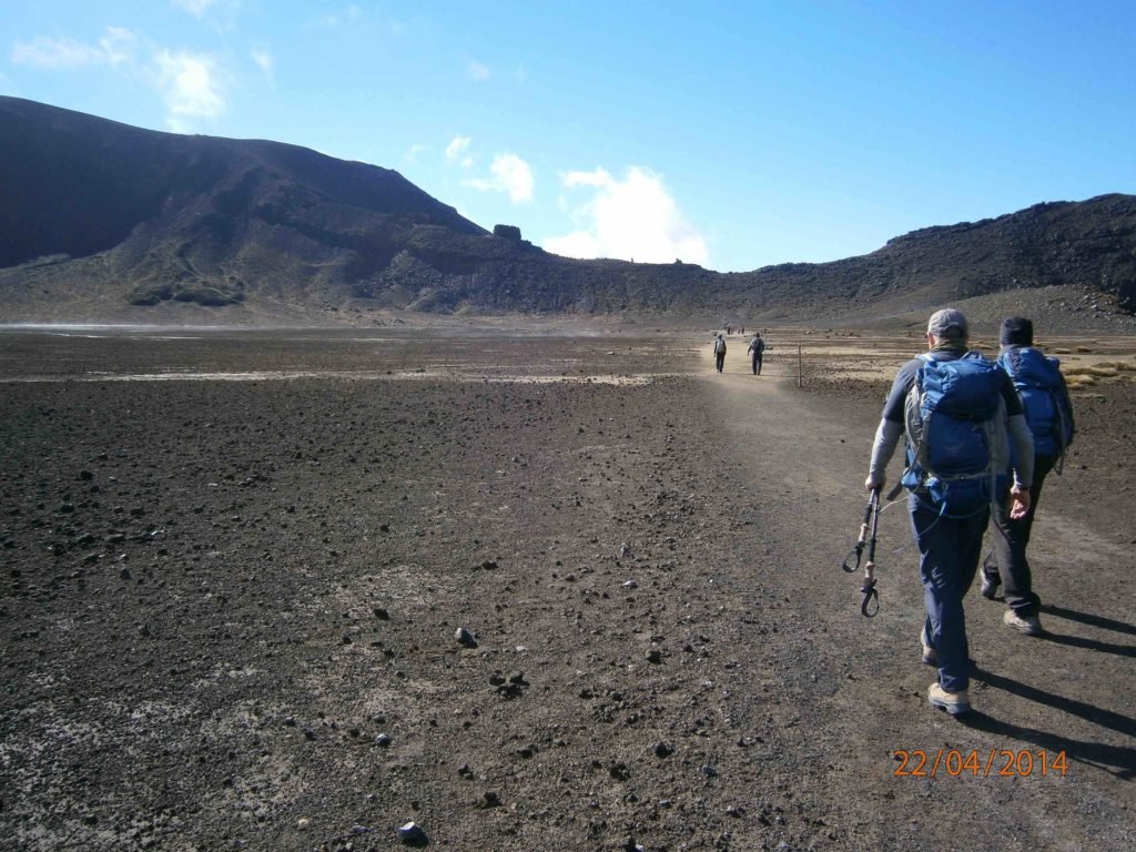 hikers going across a long flat stretch across an old crater