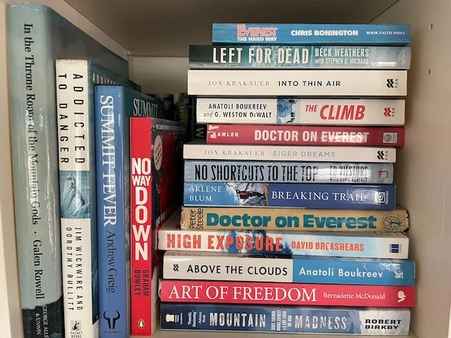 a bookshelf containing a stack of Books about mountaineering in the 1970s, 80s and 90s