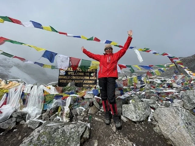 Emma at the sign marking the top of the Larkya La Pass