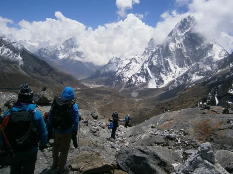 trekkers descending the Cho La Pass down a rocky slope