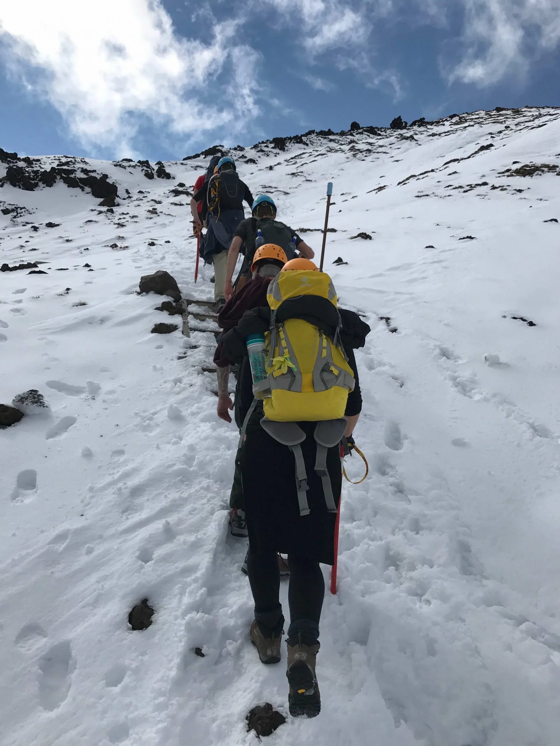 hikers heading uphill in the snow