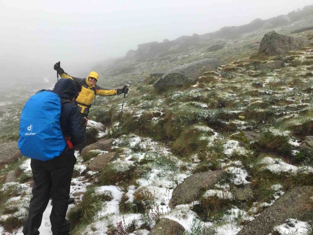 hikers in misty snowy conditions in their wet weather gear