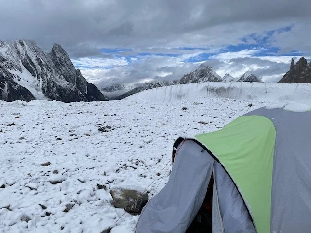 early morning photo of a single tent on the snow-covered glacier