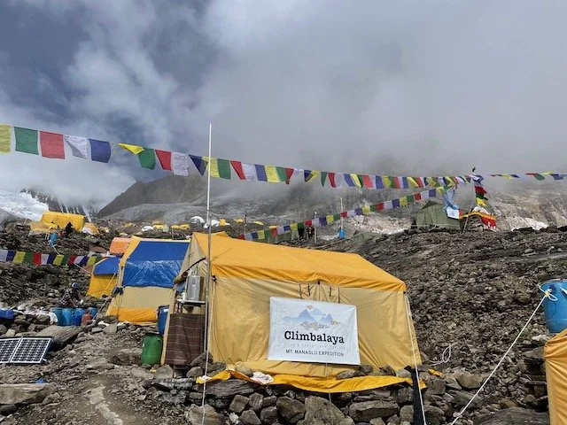 Climbalaya expedition dining tent with prayer flags flying above after the puja